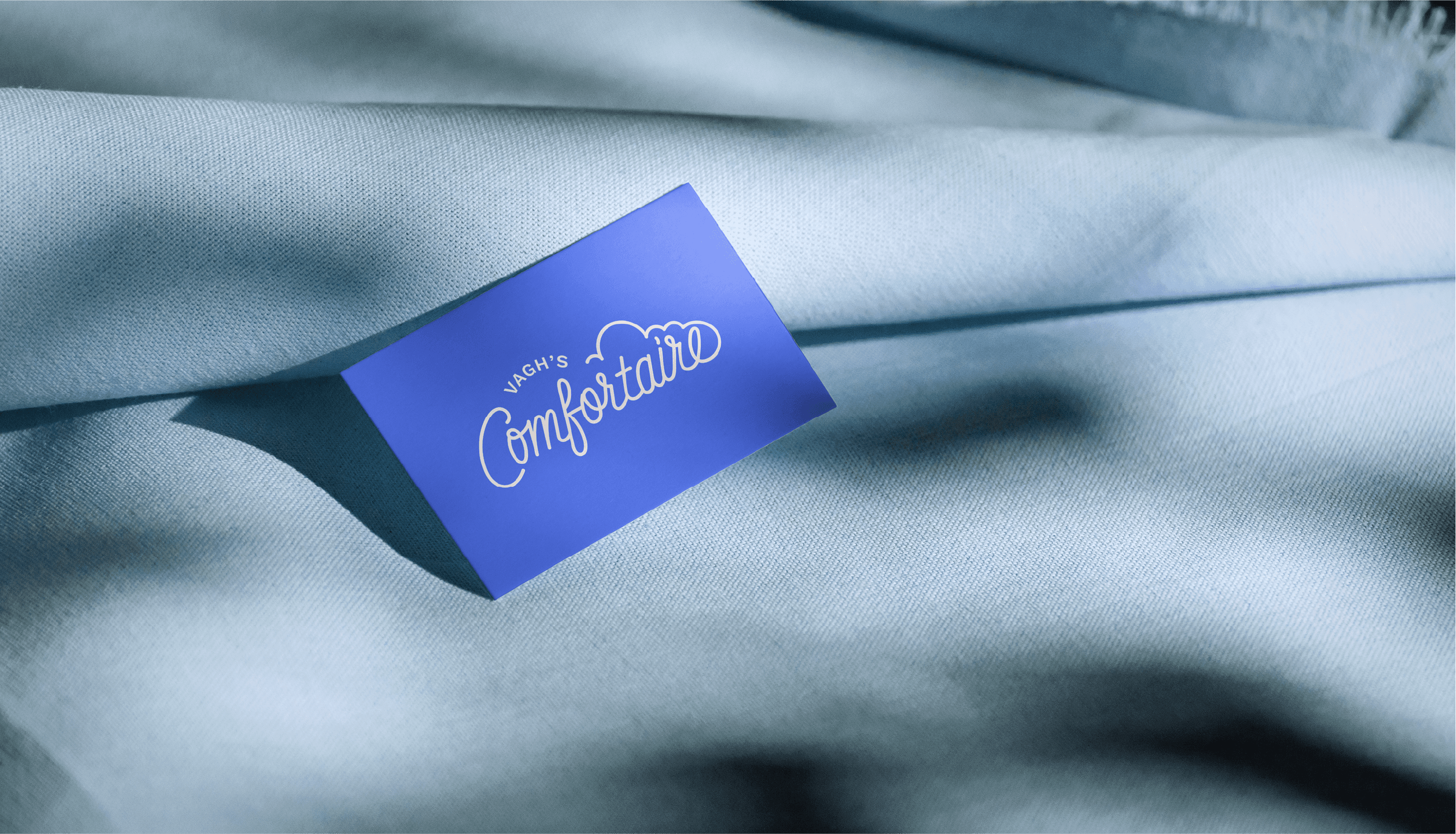 Fabric label mockup — blue branded tag sewn into bedding textile, showing logo at application scale